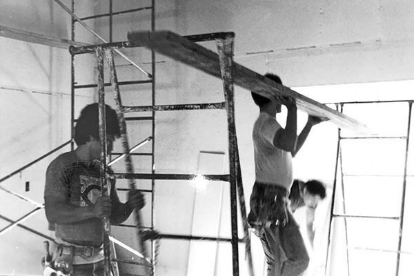 Two men hung drywall in a wood framed apartment in 1960s