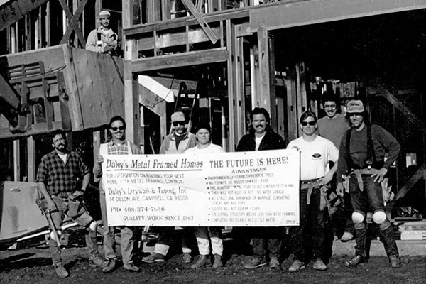 Daley's Drywall crew in front of the metal-framed house in 1980s
